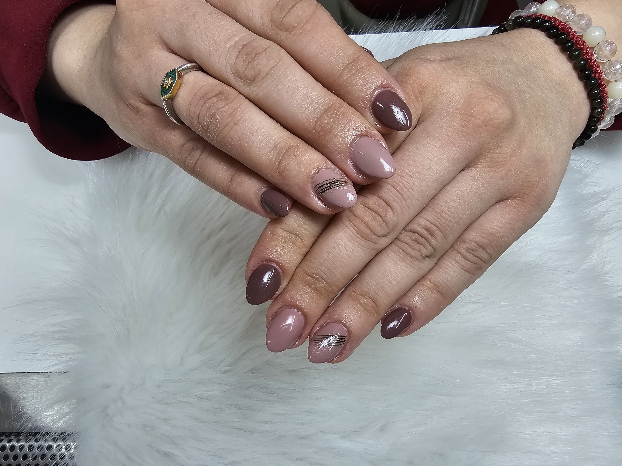 Nude en bruine nagels met zilveren lijnen op wit bont